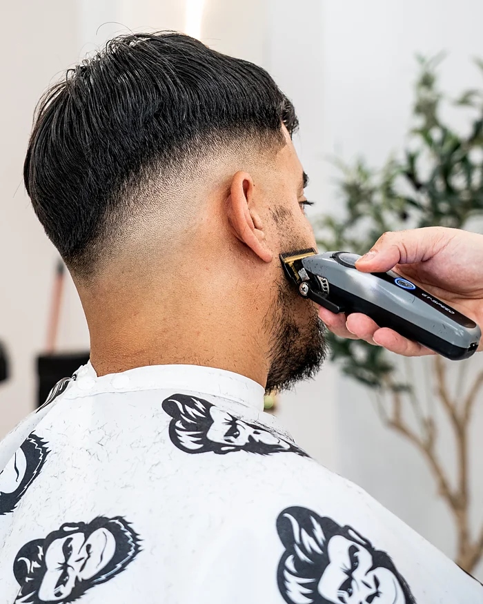 Dégradé haut et contour de barbe à la tondeuse, vu de dos